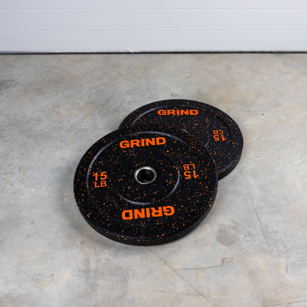 Orange. 15lb GRIND Fitness Black Carbon Weight Plates with Orange Colored Fleck pieces on each plate.
