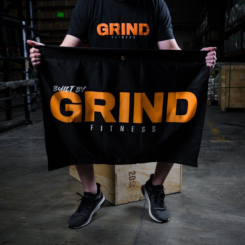 Holding Up The 'Built By GRIND Fitness' Flag While Seated