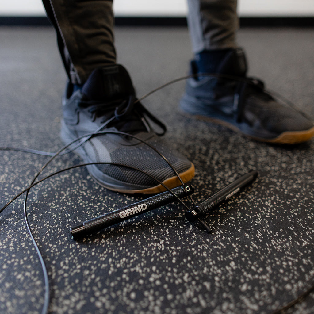 GRIND jump rope on the ground with man's feet