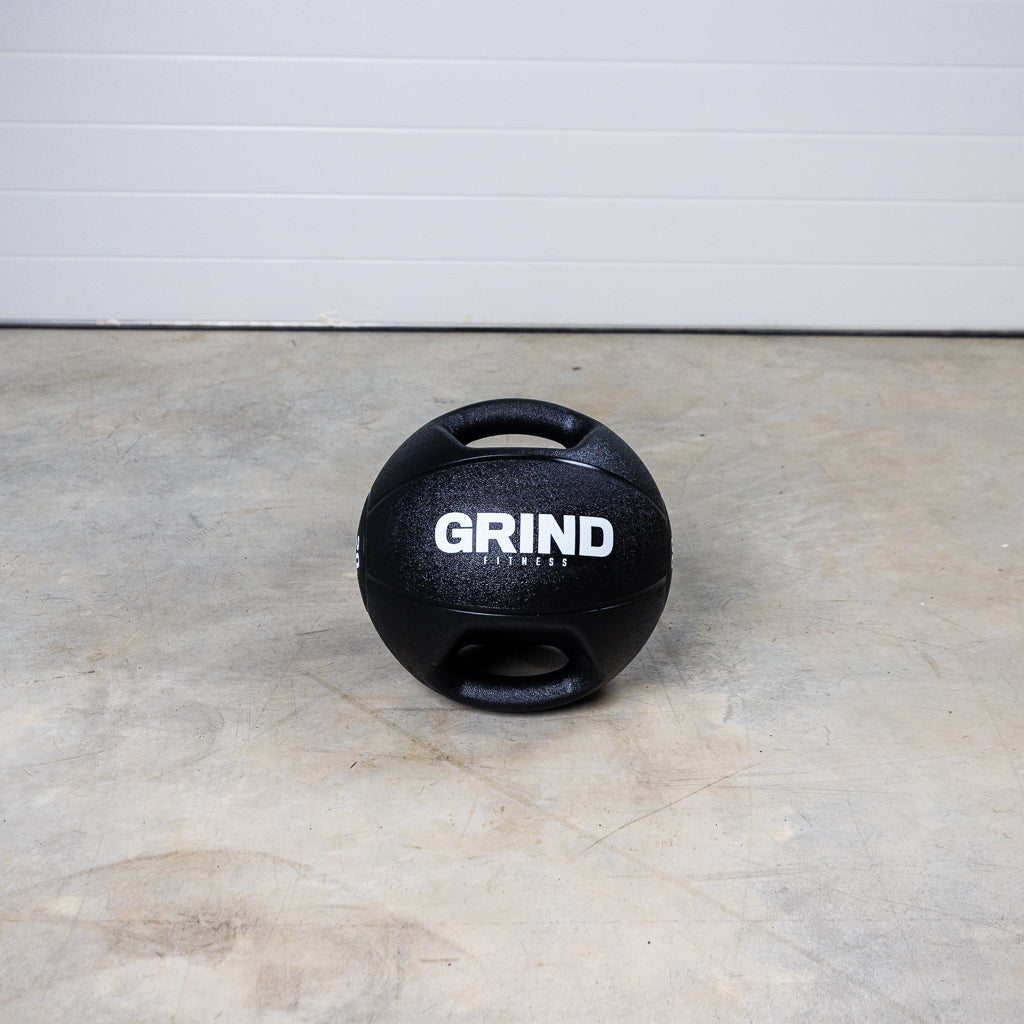 Dual-Grip Medicine Ball on floor, turned so both handles are visible.