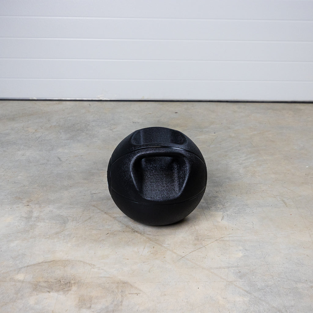 Dual-Grip Medicine Ball on floor with one handle visible.