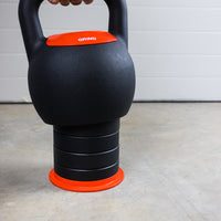 Thumbnail for Person lowering the GRIND Adjustable Kettlebell onto a stack of weight inserts.
