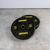 Thumbnail for Yellow 35lb GRIND Fitness Black Carbon Weight Plates with Yellow Colored Fleck pieces on each plate.