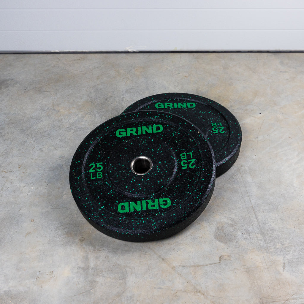 Green 25lb GRIND Fitness Black Carbon Weight Plates with Green Colored Fleck pieces on each plate.