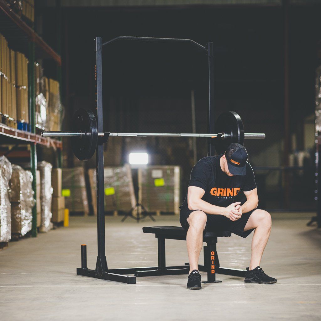 Man on flat bench sitting in front of Alpha1000 Squat Stand