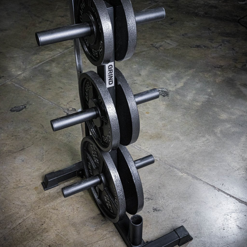 The GRIND Fitness 6-Post Weight Tree + Barbell Storage. With weight plates on the pegs.