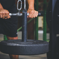 Thumbnail for Pulling Down The GRIND Fitness Pulley System Displaying The Weight Post With a Black Crumb Rubber Bumper Plates